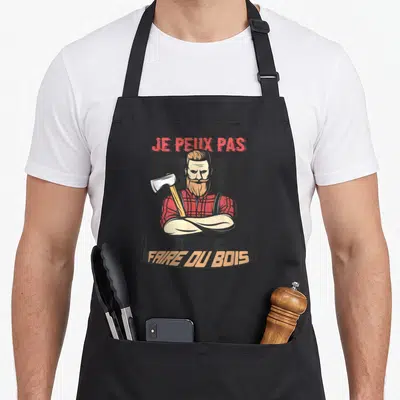 Tablier de cuisine noir avec illustration d'un bûcheron barbu tenant une hache et le texte Je peux pas je dois faire du bois.