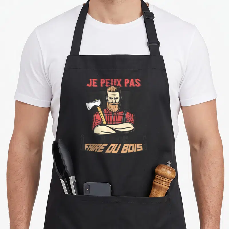 Tablier de cuisine noir avec illustration d'un bûcheron barbu tenant une hache et le texte Je peux pas je dois faire du bois.