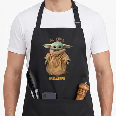Tablier de cuisine noir avec The Child du Mandalorian et inscriptions oranges THE CHILD MANDALORIAN