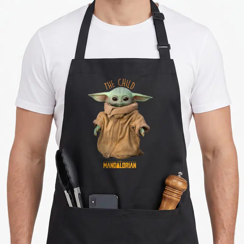 Tablier de cuisine noir avec The Child du Mandalorian et inscriptions oranges THE CHILD MANDALORIAN