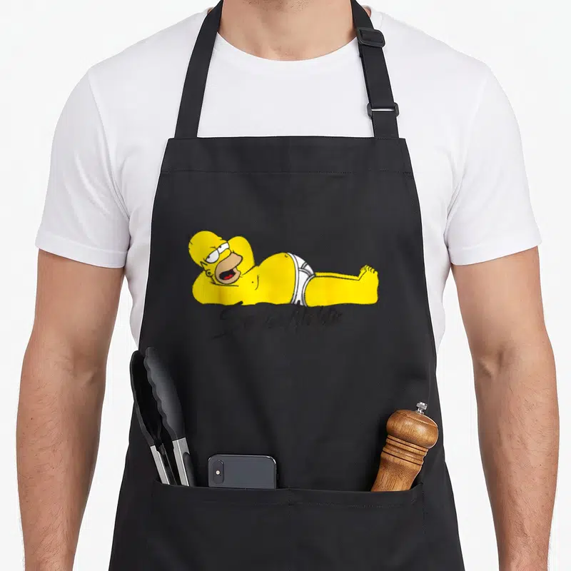 Tablier de cuisine noir avec Homer Simpson allongé en caleçon blanc et le texte Sexy and Athletic imprimé en dessous.