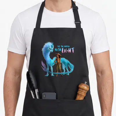 Tablier de cuisine noir avec Raya, le dragon Sisu bleu et l'inscription Fill the world with light.