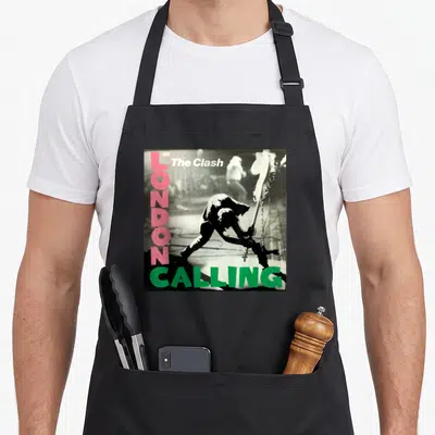Tablier de cuisine noir avec illustration album London Calling The Clash texte rose et vert guitariste en silhouette