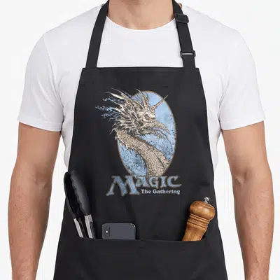 Tablier de cuisine noir avec illustration de tête de dragon et logo Magic The Gathering en bleu.