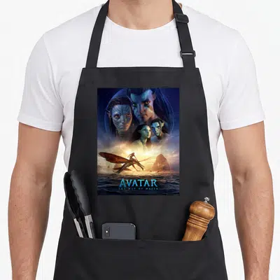 Tablier de cuisine noir avec affiche d'Avatar The Way of Water montrant des Na'vi et un Ikrax au-dessus de l'eau.