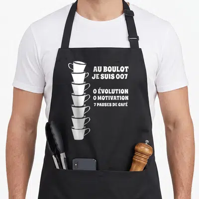 Tablier de cuisine noir avec une pile de sept tasses blanches et un texte humoristique sur le travail et le café.