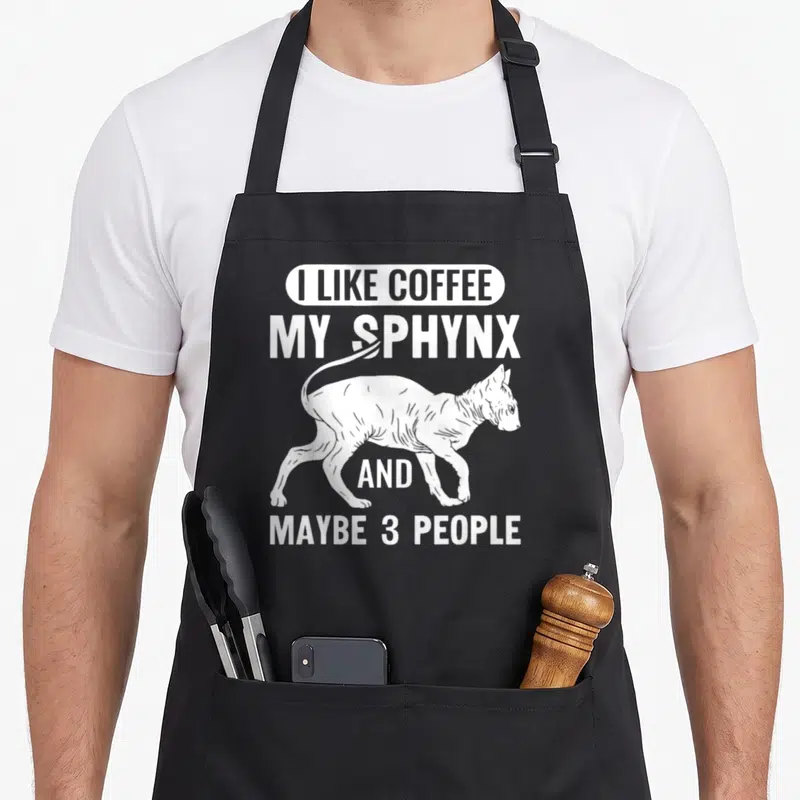 Tablier de cuisine noir avec inscription blanche J'aime le Café Mon Sphynx et illustration d'un chat sphinx en marche.
