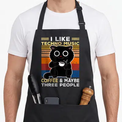 Tablier de cuisine noir avec un chat noir tenant une tasse de coffee devant des bandes colorées vintage.