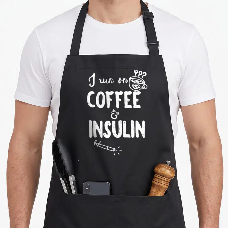 Tablier de cuisine noir avec inscription blanche I run on coffee & insulin et dessin de tasse de café.