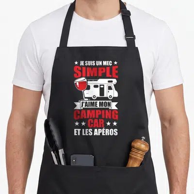 Tablier de cuisine noir avec illustration de camping-car, verre de vin et texte blanc et rouge.