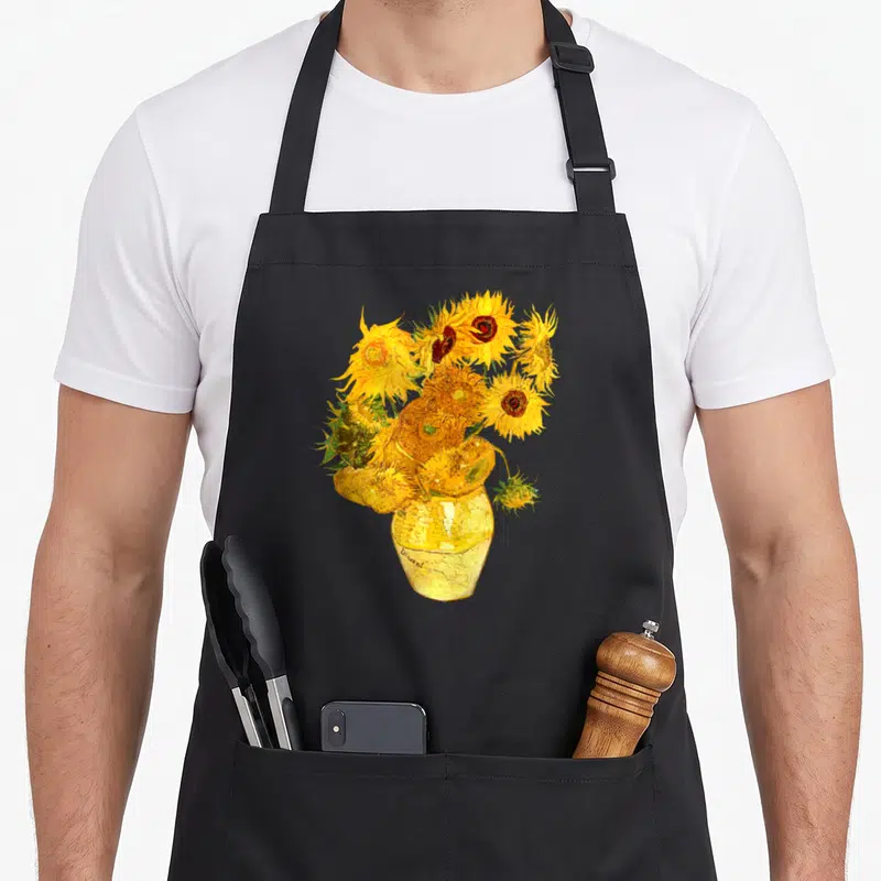 Tablier de cuisine noir avec une reproduction des tournesols de Van Gogh dans un vase jaune, style expressionniste et peinture à la main.