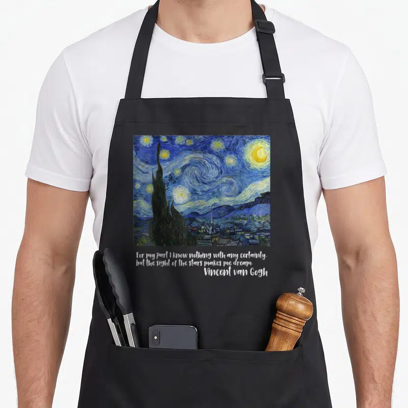 Tablier de cuisine noir avec reproduction de la Nuit étoilée de Van Gogh et citation en anglais en bas.