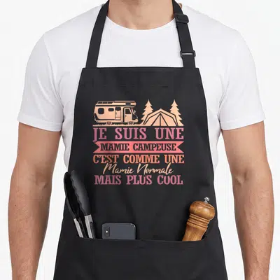 Tablier de cuisine noir avec illustration de camping-car, tente et texte Je Suis Une Mamie Campeuse en rose.