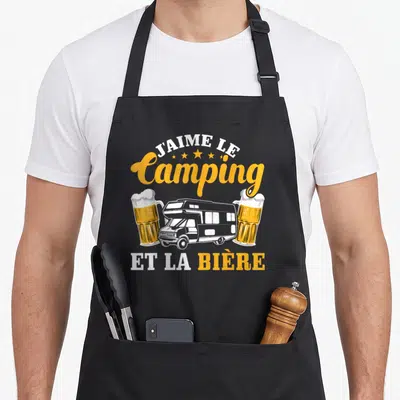 Tablier de cuisine noir avec illustration d'un camping-car entre deux verres de bière et le texte J'aime le Camping et la Bière.