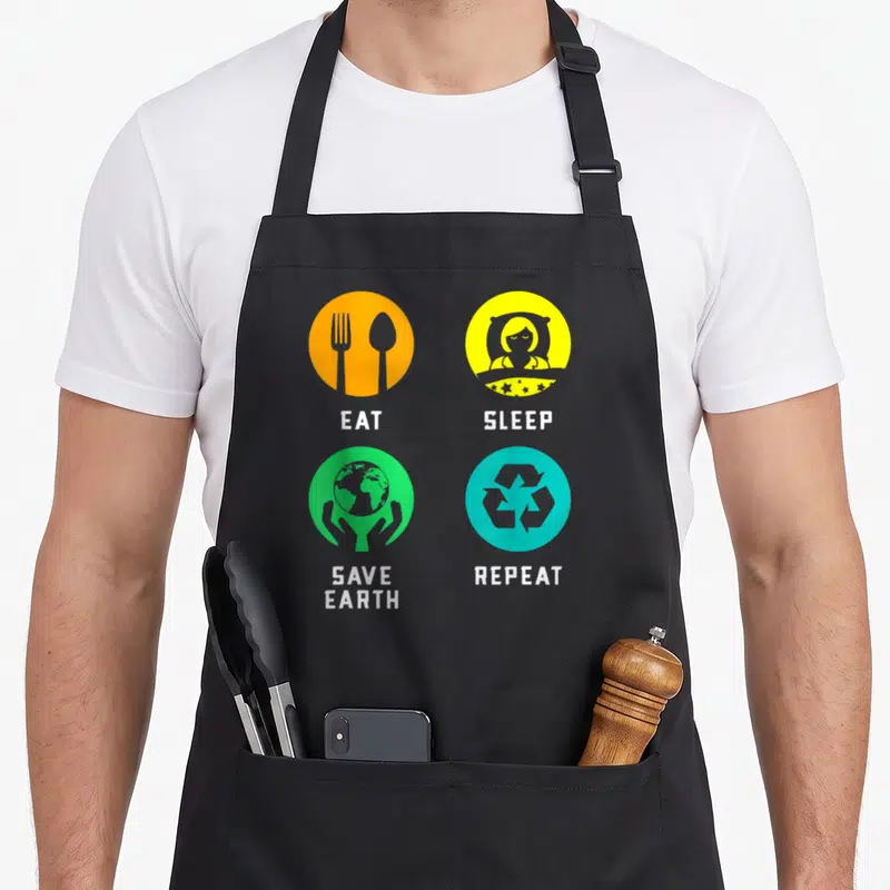 Tablier de cuisine noir avec quatre icônes colorées Eat Sleep Save Earth Repeat.