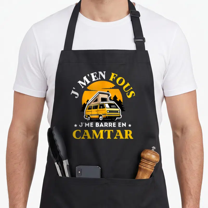 Tablier de cuisine noir avec illustration de van jaune Camtar et texte J m'en fous j me barre en Camtar sur fond de soleil orange.