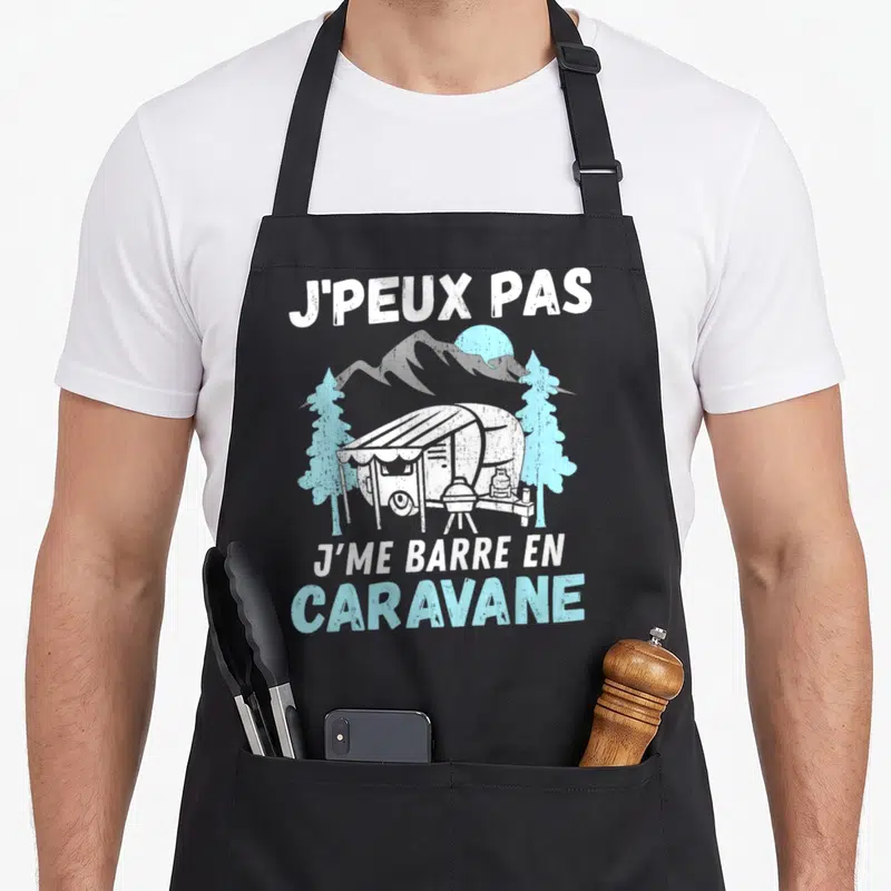 Tablier de cuisine noir avec illustration d'une caravane blanche, de pins bleus et du texte J'peux pas j'me barre en caravane