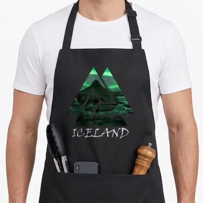 Tablier de cuisine noir avec motif triangle Islande aurore boréale verte et texte blanc ICELAND en dessous.