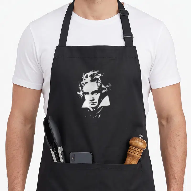 Tablier de cuisine noir avec portrait stylisé en blanc de Ludwig van Beethoven au regard intense.