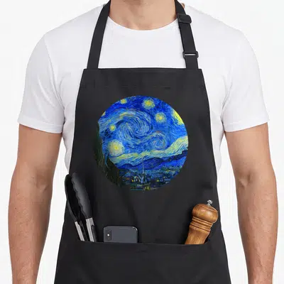 Tablier de cuisine noir avec reproduction circulaire de la Nuit étoilée de Van Gogh, étoiles jaunes et village bleu.