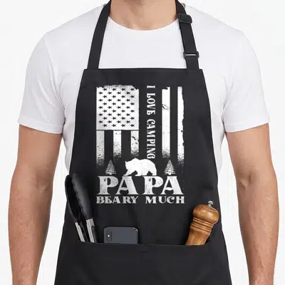 Tablier de cuisine noir avec silhouette d'ours, sapins et texte I Love Camping Papa Beary Much en blanc.