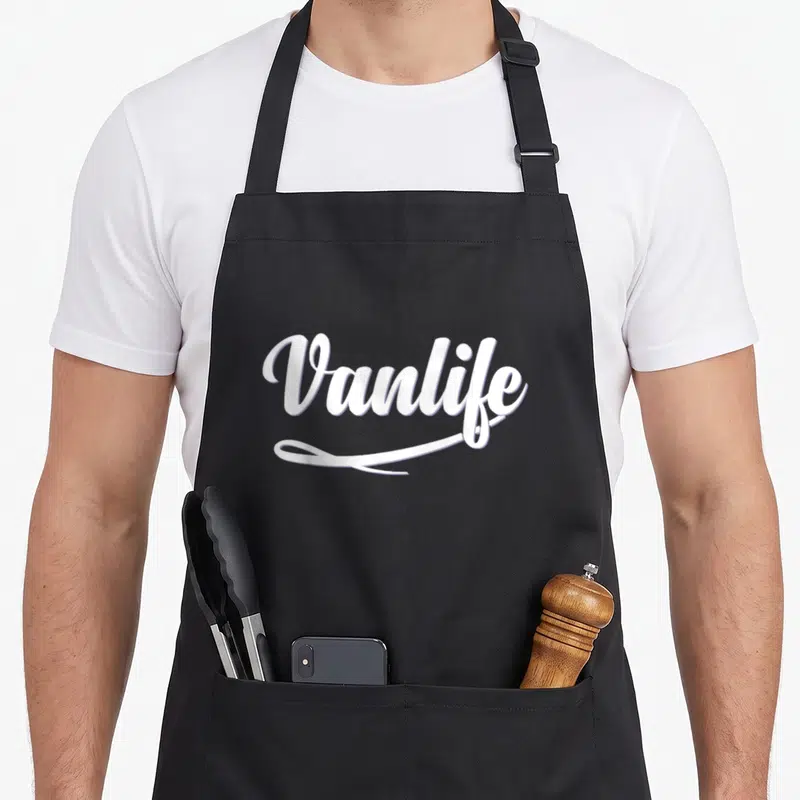 Tablier de cuisine noir avec l'inscription Vanlife en blanc et une ligne souscrite élégante.