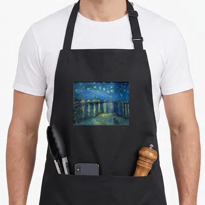 Tablier de cuisine noir avec reproduction de la Nuit étoilée sur le Rhône de Van Gogh montrant un couple sous des étoiles jaunes.