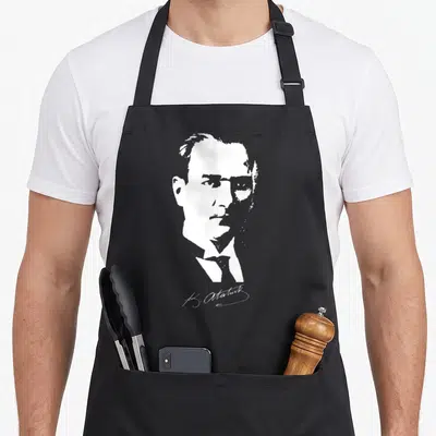 Tablier de cuisine noir avec portrait stylisé blanc de K. Atatürk et sa signature en bas à droite.