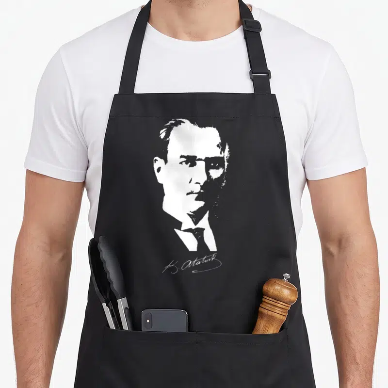 Tablier de cuisine noir avec portrait stylisé blanc de K. Atatürk et sa signature en bas à droite.