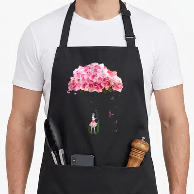 Tablier de cuisine noir avec parapluie de roses roses, ballerine et texte never give up imprimé au centre.