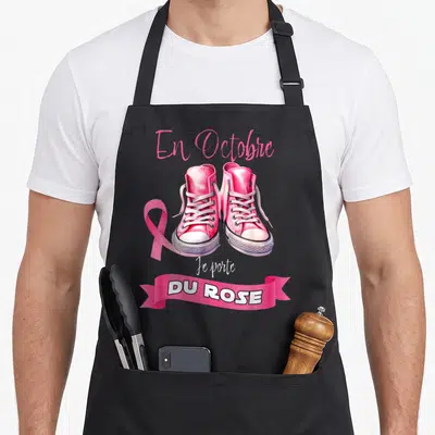 Tablier de cuisine noir avec des baskets roses, un ruban rose et l'inscription En Octobre Je porte DU ROSE.