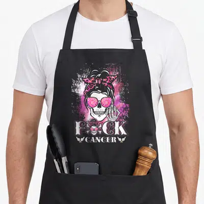 Tablier de cuisine noir avec un crâne de femme aux lunettes roses et l'inscription F*ck Cancer en blanc.