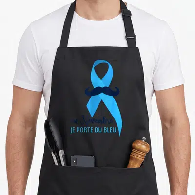 Tablier de cuisine noir avec ruban bleu, moustache noire et texte en novembre je porte du bleu imprimé au centre.