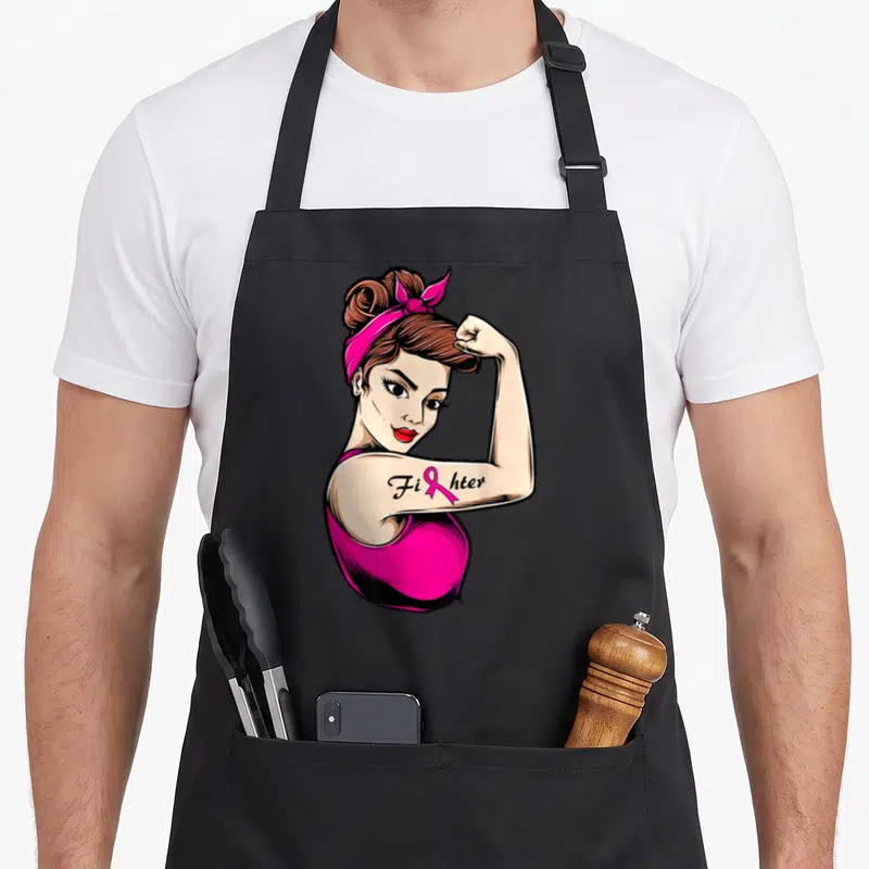 Tablier de cuisine noir avec illustration Rosie la Riveter et texte Fihter sur le bras.