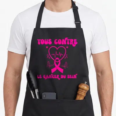 Tablier de cuisine noir avec un ruban rose, un cœur et l'inscription Tous contre le cancer du sein en lettres roses.