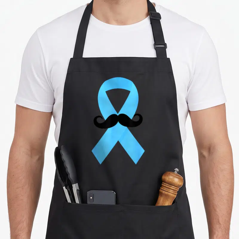 Tablier de cuisine noir avec un grand ruban bleu traversé par une moustache noire incurvée au centre.