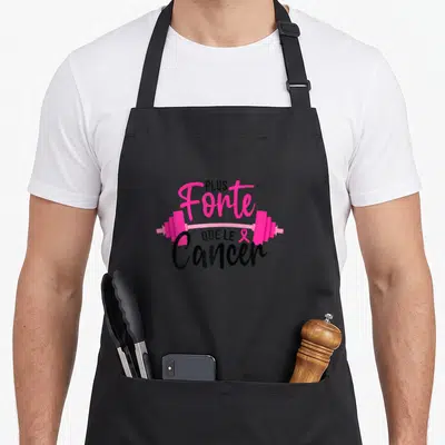 Tablier de cuisine noir avec une illustration de barre de poids rose et texteant imprimé au centre.