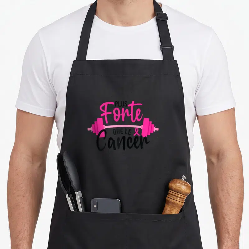 Tablier de cuisine noir avec une illustration de barre de poids rose et texteant imprimé au centre.