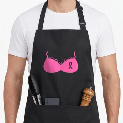 Tablier de cuisine noir avec illustration soutien Octobre Ruban Rose Combattre Cancer Du Sein sur fond uni gris.
