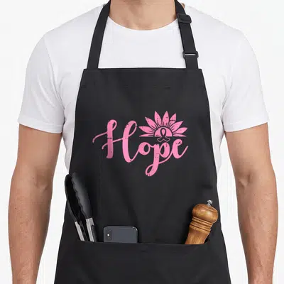 Tablier de cuisine noir avec l'inscription Hope en rose et un ruban stylisé en fleur.