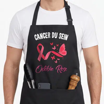 Tablier de cuisine noir avec un ruban rose, des papillons et les mots Cancer du Sein Octobre Rose imprimés en blanc et rose.