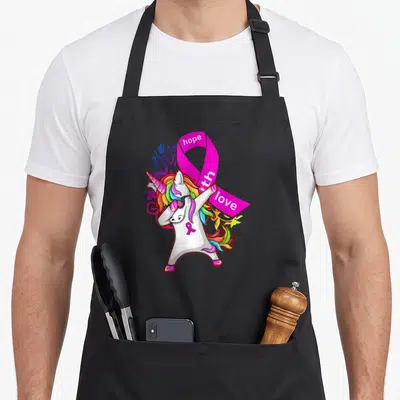 Tablier de cuisine noir avec licorne blanche en train de faire le dab et un grand ruban rose.