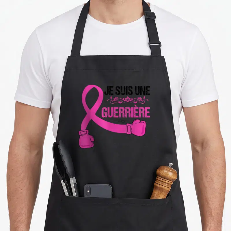 Tablier de cuisine noir avec un ruban rose transformé en gant de boxe et le texte Je suis une guerrière du cancer.