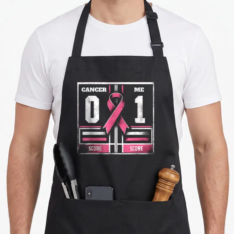 Tablier de cuisine noir avec motif score Cancer 0 Me 1 et ruban rose stylisé arcade.
