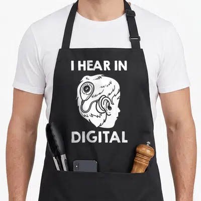 Tablier de cuisine noir avec illustration tête et texte I hear in digital en blanc.