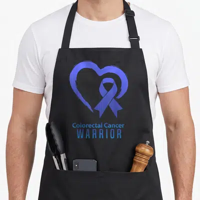 Tablier de cuisine noir avec un cœur bleu et un ruban de sensibilisation au cancer colorectal.