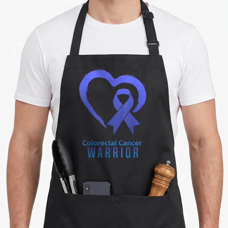 Tablier de cuisine noir avec un cœur bleu et un ruban de sensibilisation au cancer colorectal.