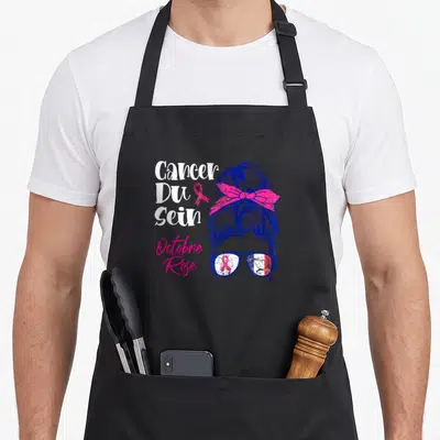 Tablier de cuisine noir avec illustration femme au chignon ruban rose et texte Cancer Du Sein Octobre Rose.