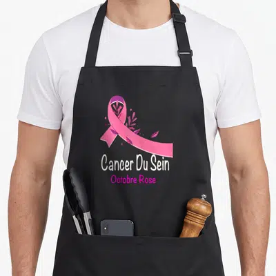 Tablier de cuisine noir avec ruban rose floral et texte Cancer Du Sein Octobre Rose imprimé au centre.