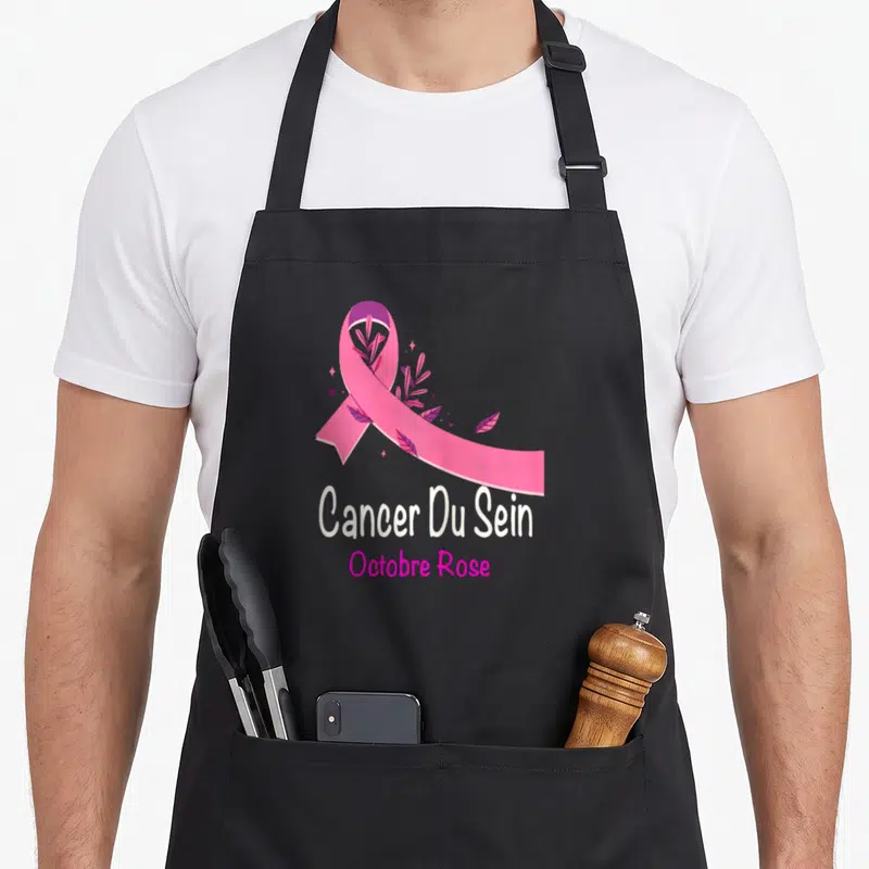Tablier de cuisine noir avec ruban rose floral et texte Cancer Du Sein Octobre Rose imprimé au centre.